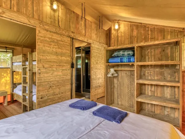 Vom Schlafzimmer mit Doppelbett aus können Sie das Kinderzimmer und das Badezimmer sehen.