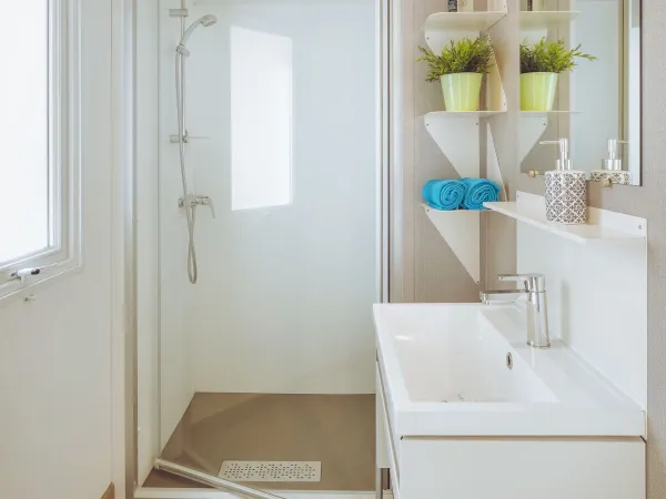 Das Roan Premium Lounge Badezimmer mit Duschkabine und Waschbecken mit Unterschrank.