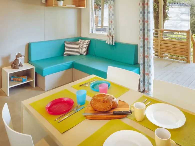 Das Wohnzimmer der Roan Premium Lounge ist mit einem gemütlichen Esstisch und einem Ecksofa ausgestattet.