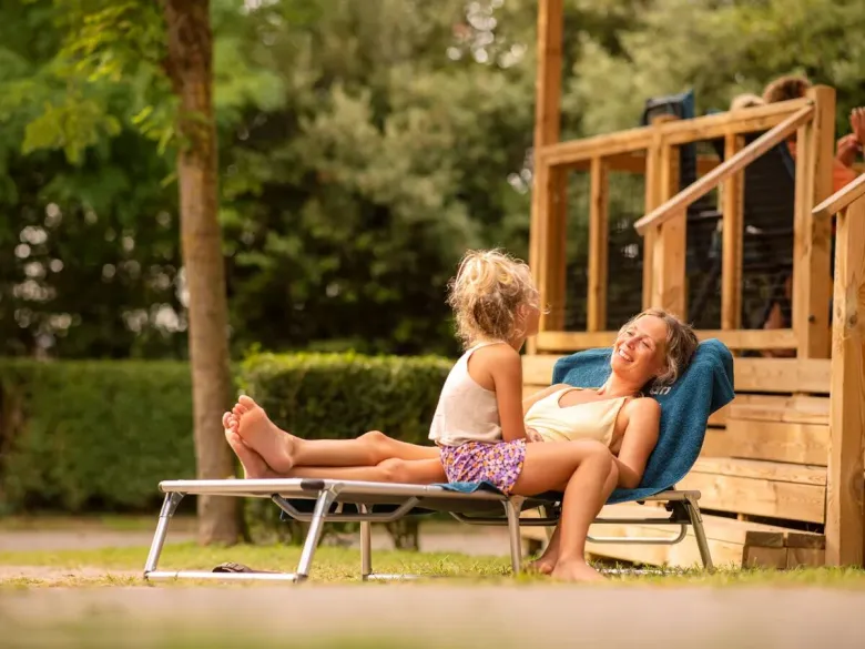 Mutter und Tochter auf dem luxuriösen Liegestuhl mit Baldachin.