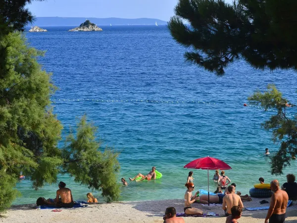 Strand mit blauem Meer auf dem Campingplatz Roan Amadria Park Trogir.