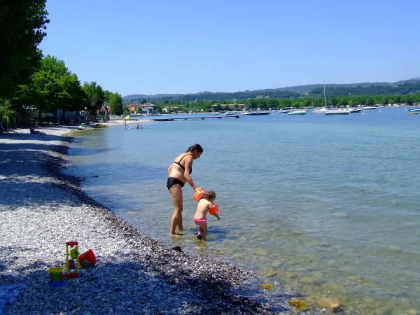 Mutter mit Baby im See auf dem Roan Campingplatz La Rocca Manerba.