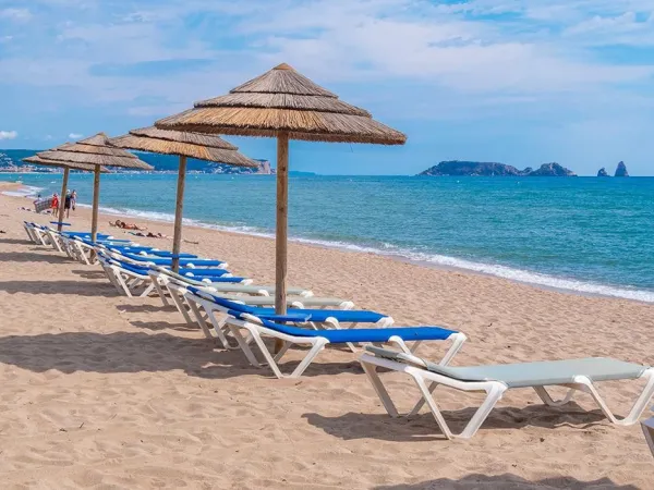 Sonnenliegen am Strand des Campingplatzes Roan in Playa Brava.