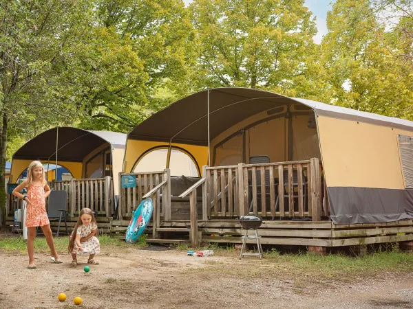 Kinder spielen vor dem Holiday Lodgetent auf dem Roan-Campingplatz La Rocca Manerba.