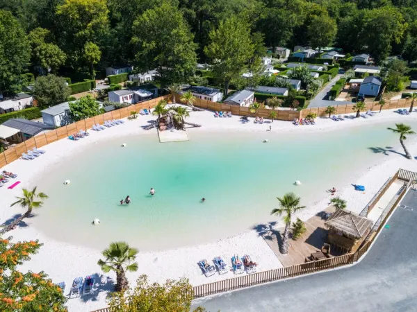 Übersicht über den Lagunenpool mit Sandstrand auf dem Campingplatz Roan La Clairière