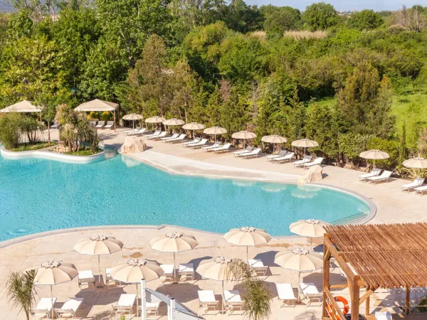 Schwimmbad mit Liegestühlen und Sonnenschirmen auf dem Campingplatz Roan La Chapelle.