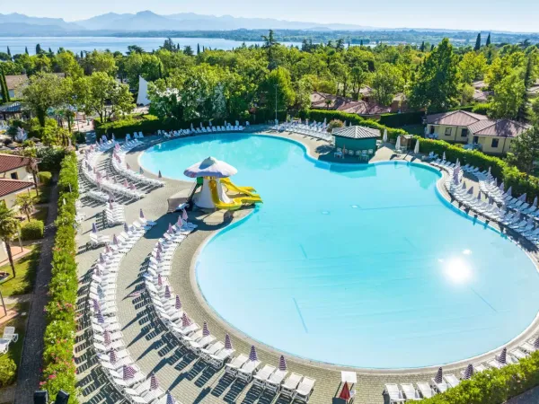 Schwimmbad mit Rutschen und Liegestühlen auf dem Campingplatz Roan Bella Italia.