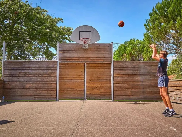 Junge spielt Basketball auf dem Campingplatz Roan in Mayotte Vacances.