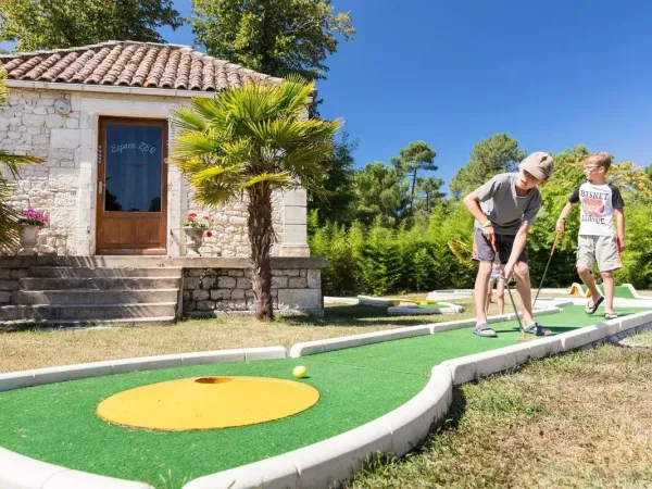 Kinder spielen Minigolf auf dem Campingplatz Roan La Clairière