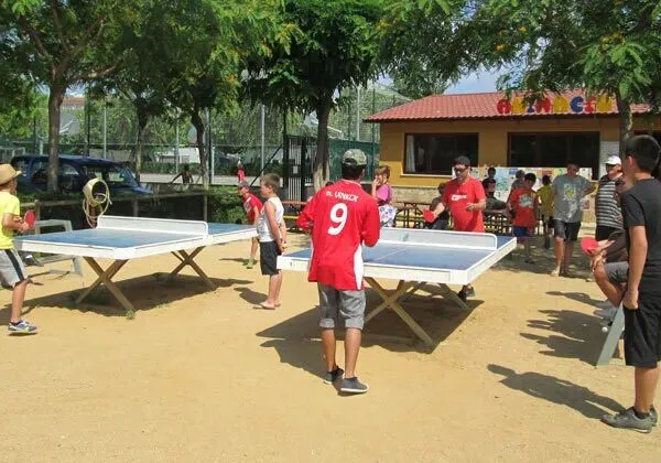 Viele Leute um die Tischtennisplatten auf dem Roan-Campingplatz La Masia.