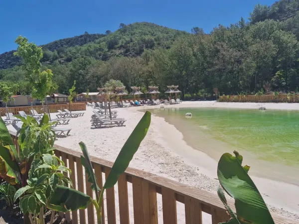 Lagunenpool mit Sandstrand und Sonnenliegen auf dem Campingplatz Roan Verdon Parc.