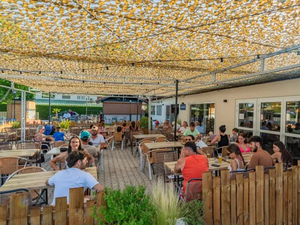 Eine angenehm gefüllte Terrasse auf dem Campingplatz Roan Château de Galaure.