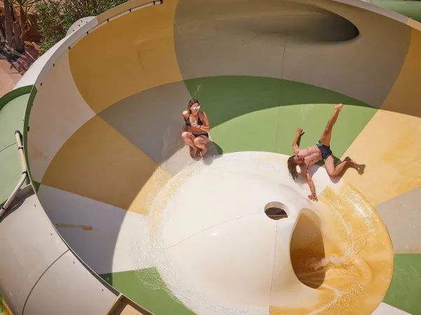 Zwei Personen amüsieren sich auf der Tornadorutsche des Campingplatzes Le Petit Mousse in Roan.