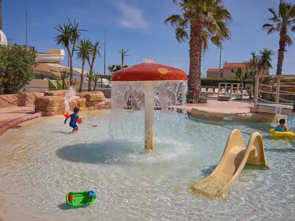 Kinderbecken mit Rutsche und Pilzsprinkler auf dem Campingplatz Le Petit Mousse in Roan.