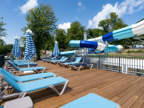 Eine Sonnenterrasse und eine Rutsche auf dem Campingplatz Le Lac des Vieilles Forges in Roan.