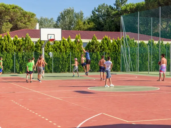 Kinder spielen eine Partie Basketball auf dem Multisportplatz des Campingplatzes Marina Julia Camping Village in Roan.