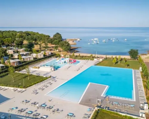 Schwimmbad mit Kinderbecken und Rutschen und Bucht auf dem Campingplatz Roan Park Umag.